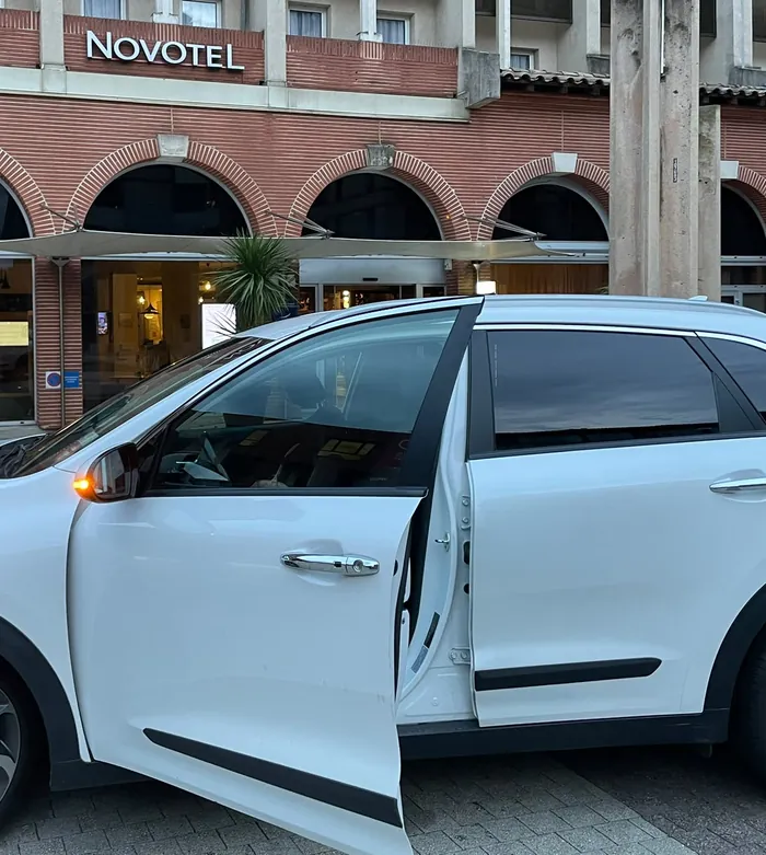 Louise VTC Express, chauffeure VTC à Toulouse : portière ouverte devant un hôtel